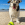 White, brown, and black dog with KONG tennis ball at the beach.