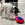 White and black dog pawing a red and blue KONG toy in a white kitchen.